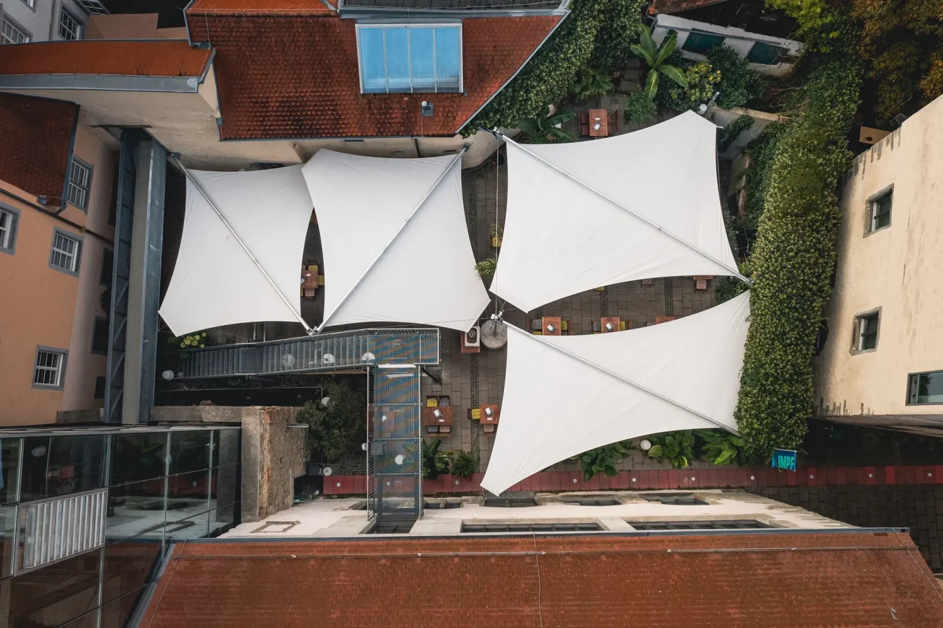 Im historischen Innenhof realisierten wir eine maßgeschneiderte Rollsegelanlage aus der Serie „Textile Bauwerke“ von BIKATEC.